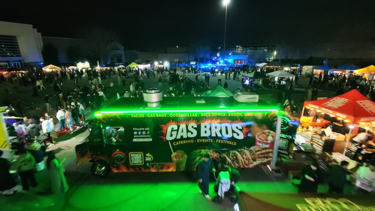 Aerial view of the Gas Bros food truck lit up in green at a night festival